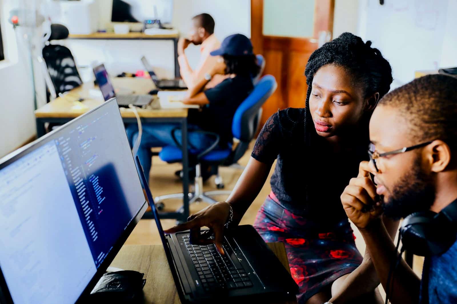 woman and man sitting in front of monitor with good relationship